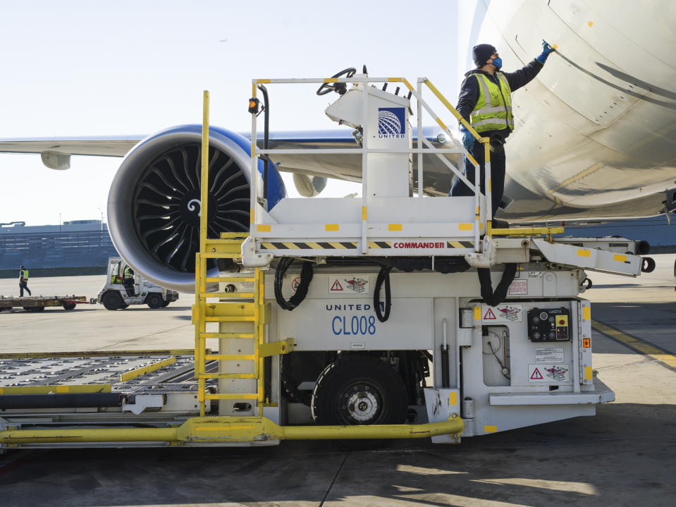 Un empleado de United Airlines se prepara para bajar la carga de un avión en Chicago, Illinois, el 4 de diciembre de 2020. (Sebastian Hidalgo / The New York Times)