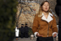 Policemen watch as a journalist reports near the Canadian Embassy in Beijing, Friday, Dec. 14, 2018. Canada is being battered by diplomatic ill winds. First, President Donald Trump attacked Canada on trade. Then Saudi Arabia punished it for speaking up for human rights. Now China has the country in its cross-hairs, detaining two Canadians in apparent retaliation for the arrest of a top Chinese tech executive on behalf of the U.S. Canada's normally reliable ally to the south has left it high and dry. (AP Photo/Andy Wong)