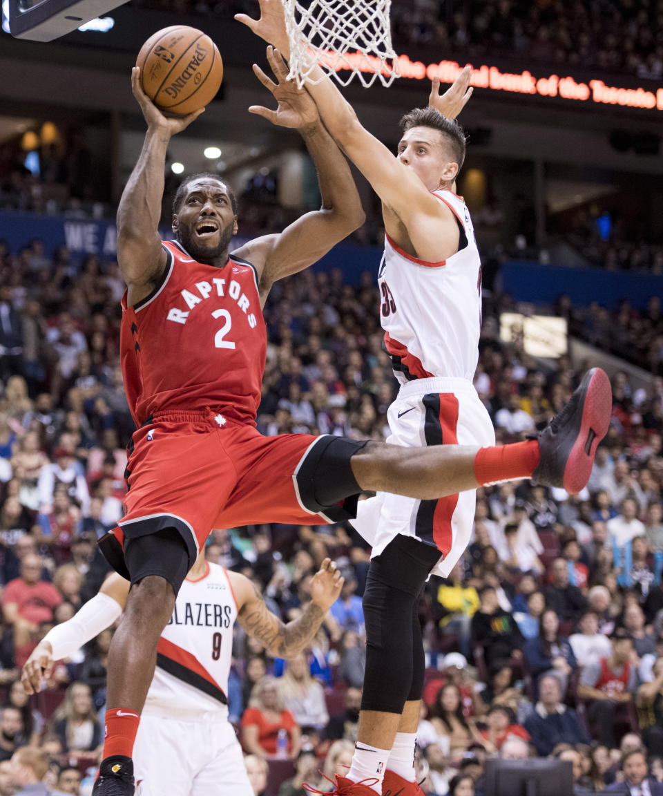 Toronto Raptors forward Kawhi Leonard (2) fights for control of the ball with Portland Trail Blazers forward Zach Collins (33) during the second half of a preseason NBA basketball game, Saturday, Sept. 29, 2018 in Vancouver, British Columbia. (Jonathan Hayward/The Canadian Press via AP)