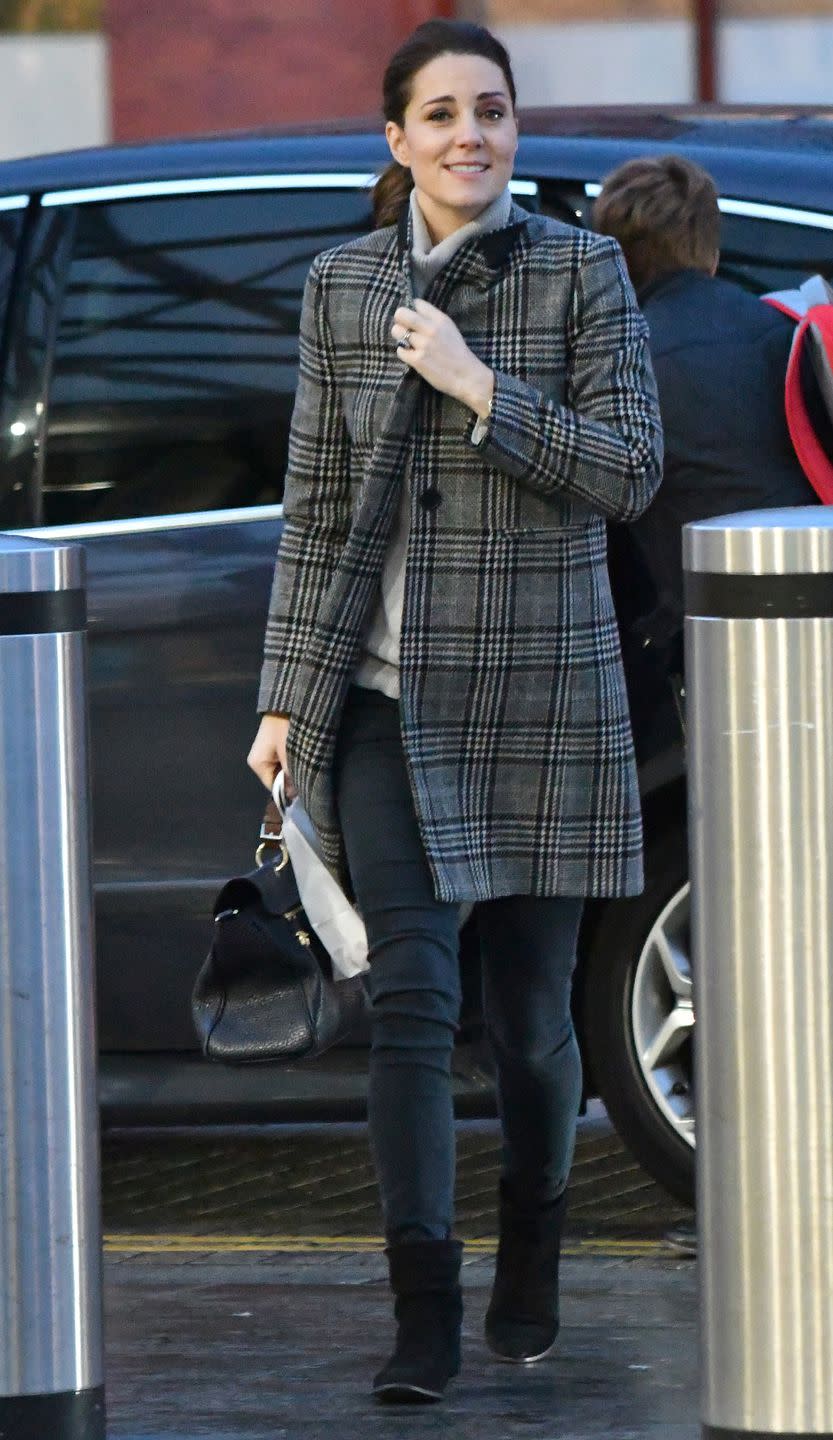 <p>In a plaid Zara coat, gray turtleneck sweater, black skinny jeans, black booties, and a leather handbag.</p>