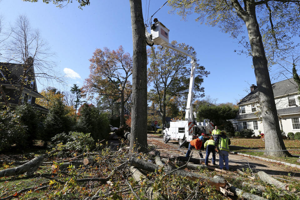 Crews from Madison Electric and Butler Municipal Power and Light work on downed power lines on Green Hill Road on Friday, Nov. 1, 2019, in Madison, N.J. The borough was hit by high winds on heavy rain late the night before. (AP Photo/Rich Schultz)