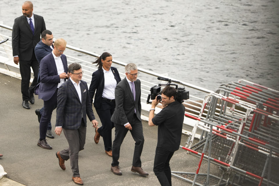 Ukrainian Foreign Minister Dmytro Kuleba, center left, surround by staff and security, walks after meetings on a street in Berlin, Germany, Thursday, May 12, 2022. (AP Photo/Markus Schreiber)