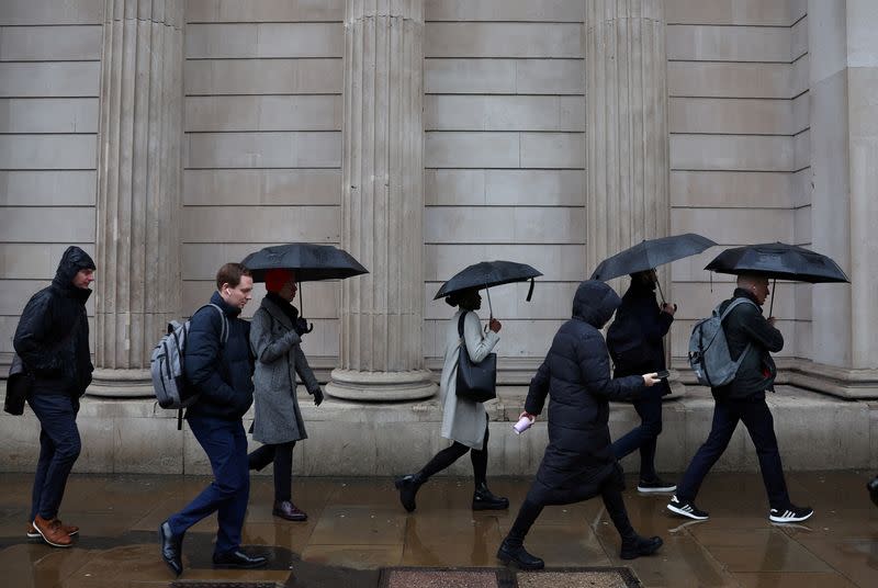 FILE PHOTO: Commuters walk in City of London financial district in London