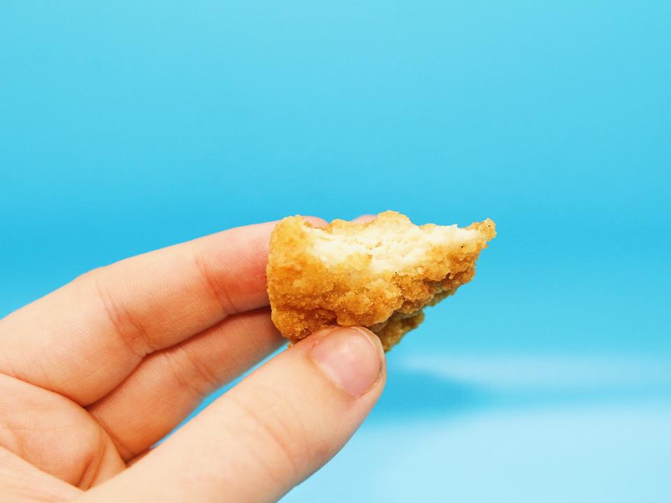 The author holds a mcdonalds chicken nugget with a bite taken from it