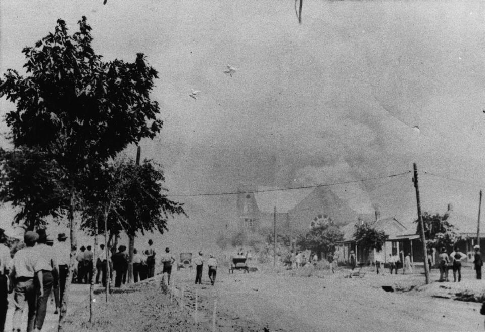 This photo provided by the Department of Special Collections, McFarlin Library, The University of Tulsa shows a crowd watching the Mt. Zion Baptist Church burn during the June 1, 1921, Tulsa Race Massacre in Tulsa, Okla. (Department of Special Collections, McFarlin Library, The University of Tulsa via AP)