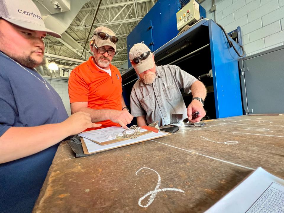Michael Beaty and Curtiss Rippy show a student how they can improve their weld at Cleveland Community College on Wednesday.