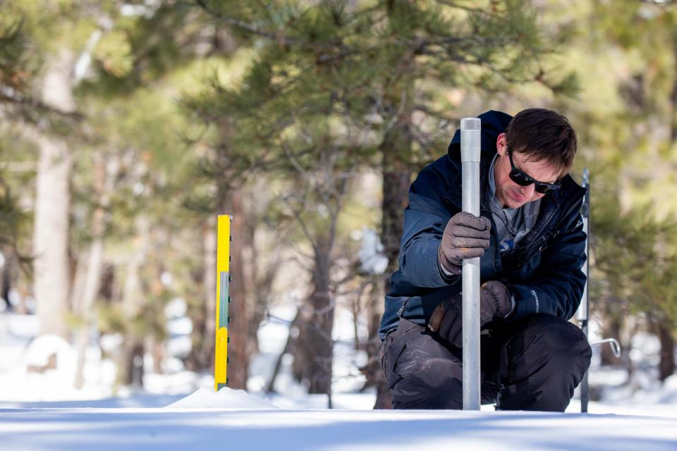 Bo Svoma, a meteorologist at Salt River Project, gathers a snow sample at a recording station in Happy Jack, AZ, on Feb. 13, 2024.