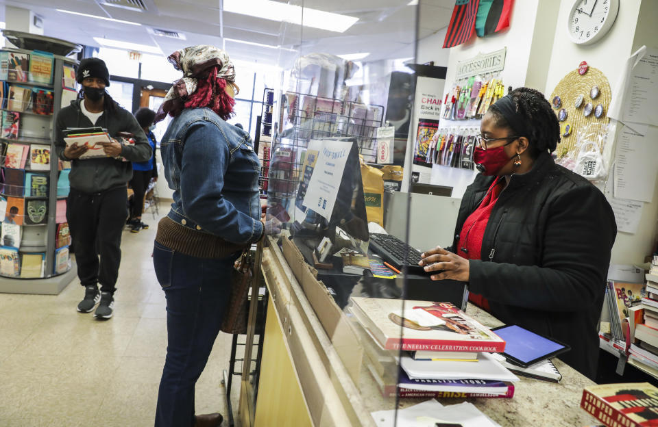 BOSTON, MA - NOVEMBER 28: A patron, left, purchases calendars from Frugal Bookstore owner Clarrissa Egerton in Boston on Nov. 28, 2020. Frugal Bookstore, the only Black-owned bookshop in Boston, has received an outpouring of support amid nationwide protests against racism and police brutality. The crowds continued to pour in for Small Business Saturday, following Black Friday, a day encouraging consumers to shop local. (Photo by Erin Clark/The Boston Globe via Getty Images)