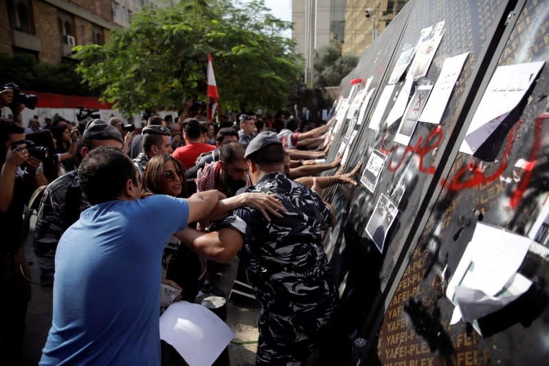 Protesters knock down the fencing as they demonstrate outside of Lebanon Central Bank during ongoing anti-government protests in Beirut