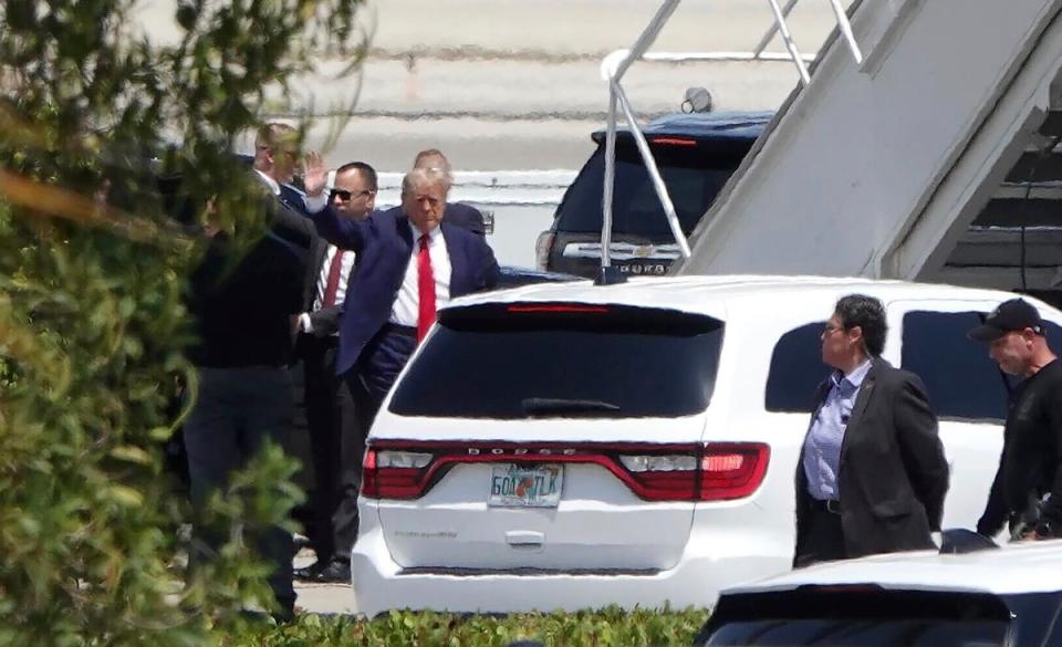 Donald Trump waves as he boards his plane at Palm Beach International Airport in Florida bound for his arraignment in New York. (AP)