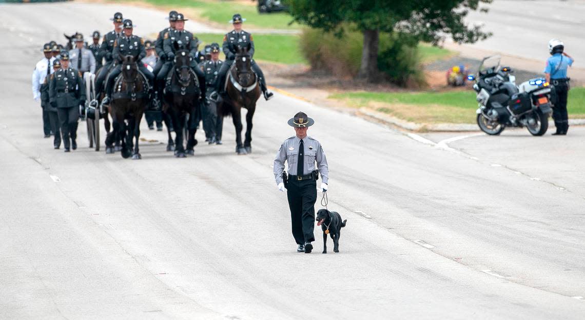 Wake County Deputy A. Staton and Sasha, K-9 partner of slain Wake County Sheriff’s Deputy Ned Byrd, lead the N.C. State Highway Patrol’s Caisson Unit during a procession for Deputy Byrd before his funeral at Providence Baptist Church in Raleigh Friday, August 19, 2022.