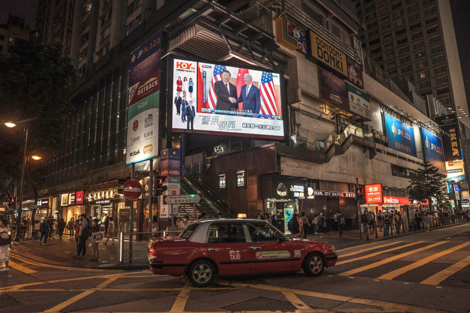 A car drives past a screen on a building feature Chinese President Xi Jinping's meeting with President Joe Biden (Lam Yik / Bloomberg via Getty Images file)