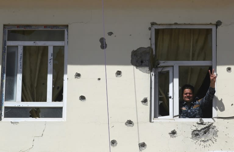 A member of the Iraqi forces flashes the sign for victory from a damaged building in Mosul on April 10, 2017