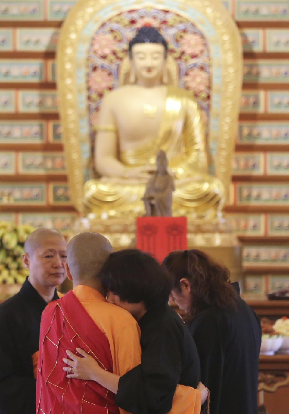 A Chinese relative of passengers on board the missing Malaysia Airlines Flight MH370 is comforted by a monk as she cries following prayers at a Buddhist temple in Petaling Jaya, Malaysia, Monday March 31, 2014. Relatives from China are in the country to seek answers of what happened to their loved one on board flight MH370. (AP Photo/Aaron Favila)