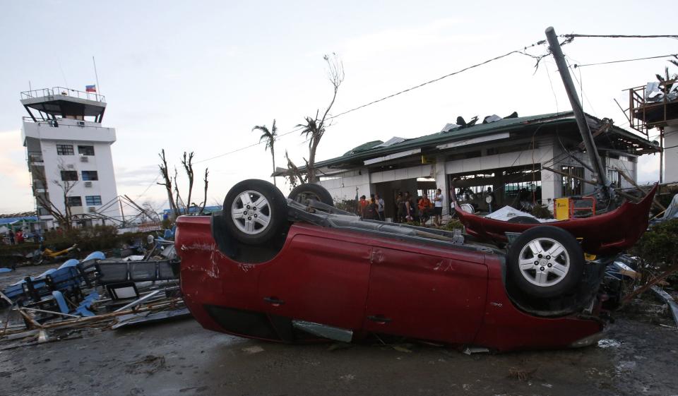 A car lies upside down outside an airport after super Typhoon Haiyan battered Tacloban city in central Philippines November 9, 2013. Possibly the strongest typhoon ever to hit land devastated the central Philippine city of Tacloban, killing at least 100 people, turning houses into rubble and leveling the airport in a surge of flood water and high wind, officials said on Saturday. The toll of death and damage from Typhoon Haiyan on Friday is expected to rise sharply as rescue workers and soldiers reach areas cut off by the massive, fast-moving storm which weakened to a category 4 on Saturday. REUTERS/Erik De Castro (PHILIPPINES - Tags: DISASTER ENVIRONMENT)
