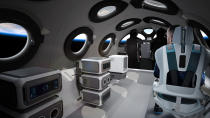 This undated photo released by Virgin Galactic shows the interior of their SpaceshipTwo Cabin during a flight. Highly detailed amenities to enhance the customer experience were shown in an online event Tuesday, July 28, 2020, revealing the cabin of the company's rocket plane, a type called SpaceShipTwo, which is undergoing testing in preparation for commercial service. There are a dozen windows for viewing, seats capable of being customized to each of six passengers and mood lighting. (Virgin Galactic via AP)