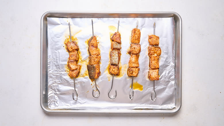 baked salmon skewers on baking sheet