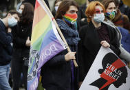 Women's rights activists with posters of the Women's Strike action protest against recent tightening of Poland's restrictive abortion law in front of the parliament building as inside, guards had to be used to shield right-wing ruling party leader Jaroslaw Kaczynski from angry opposition lawmakers, in Warsaw, Poland, on Tuesday, Oct. 27, 2020. Massive nationwide protests have been held ever since a top court ruled Thursday that abortions due to fetal congenital defects are unconstitutional. Slogan reads 'Women’s Strike'. (AP Photo/Czarek Sokolowski)