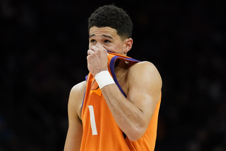 Phoenix Suns guard Devin Booker (1) watches during the second half of an NBA basketball game against the New Orleans Pelicans, Friday, Feb. 25, 2022, in Phoenix. (AP Photo/Matt York)