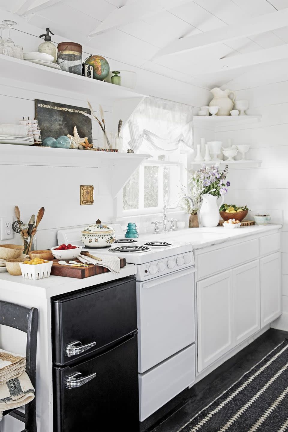 <p>By sticking to a black-and-white color scheme, Paige makes her modestly sized kitchen appear much larger than it really is.</p><p><a class="link " href="https://www.amazon.com/Life-Changing-Magic-Tidying-Decluttering-Organizing/dp/1607747308?tag=syn-yahoo-20&ascsubtag=%5Bartid%7C10050.g.1887%5Bsrc%7Cyahoo-us" rel="nofollow noopener" target="_blank" data-ylk="slk:SHOP TIDYING BOOKS;elm:context_link;itc:0;sec:content-canvas">SHOP TIDYING BOOKS</a></p>