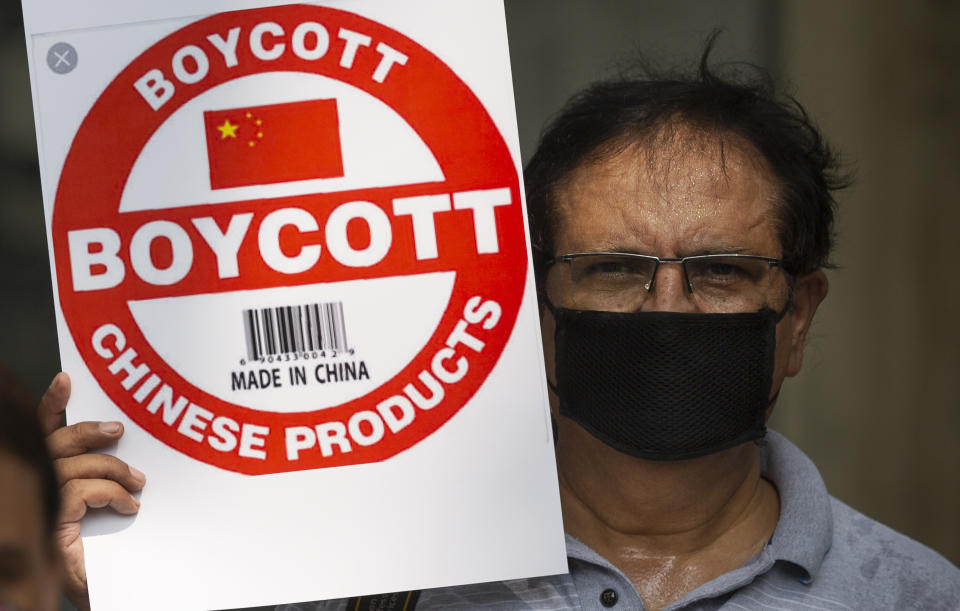 An Indian journalist holds a placard calling for boycott of Chinese products during a protest organized by Working Journalists of India, in New Delhi, India, Tuesday, June 30, 2020. India on Monday banned 59 apps with Chinese links, saying their activities endanger the country’s sovereignty, defense and security. India’s decision comes as its troops are involved in a tense standoff with Chinese soldiers in eastern Ladakh in the Himalayas that started last month. India lost 20 soldiers in a June 15 clash. (AP Photo/Altaf Qadri)
