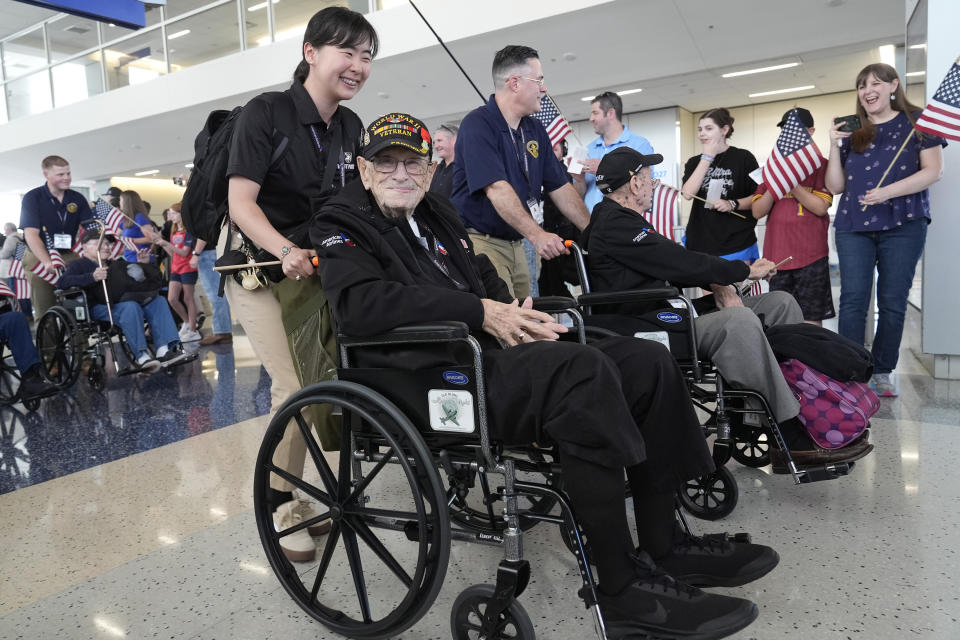World War II veteran Henry Armstrong, front, is pushed along by Ye Jin Bae as they make their way to board a plane at Dallas Fort Worth International Airport in Dallas Friday, May 31, 2024. A group of World War II veterans are being flown from Texas to France where they will take part in ceremonies marking the 80th anniversary of D-Day. (AP Photo/LM Otero)