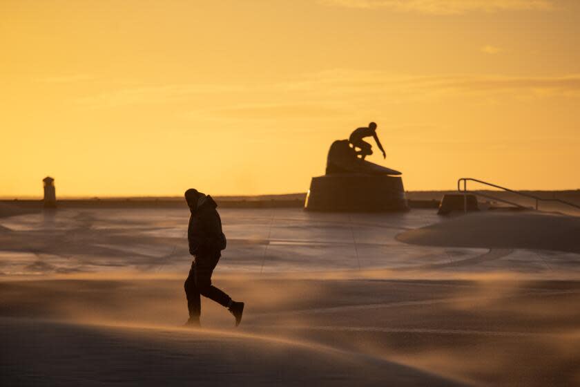 Hermosa Beach, CA - February 22: High winds blew sand inland, pelting walkers and piling up, along Pier Plaza, in Hermosa Beach, CA, Wednesday, Feb. 22, 2023. (Jay L. Clendenin / Los Angeles Times)