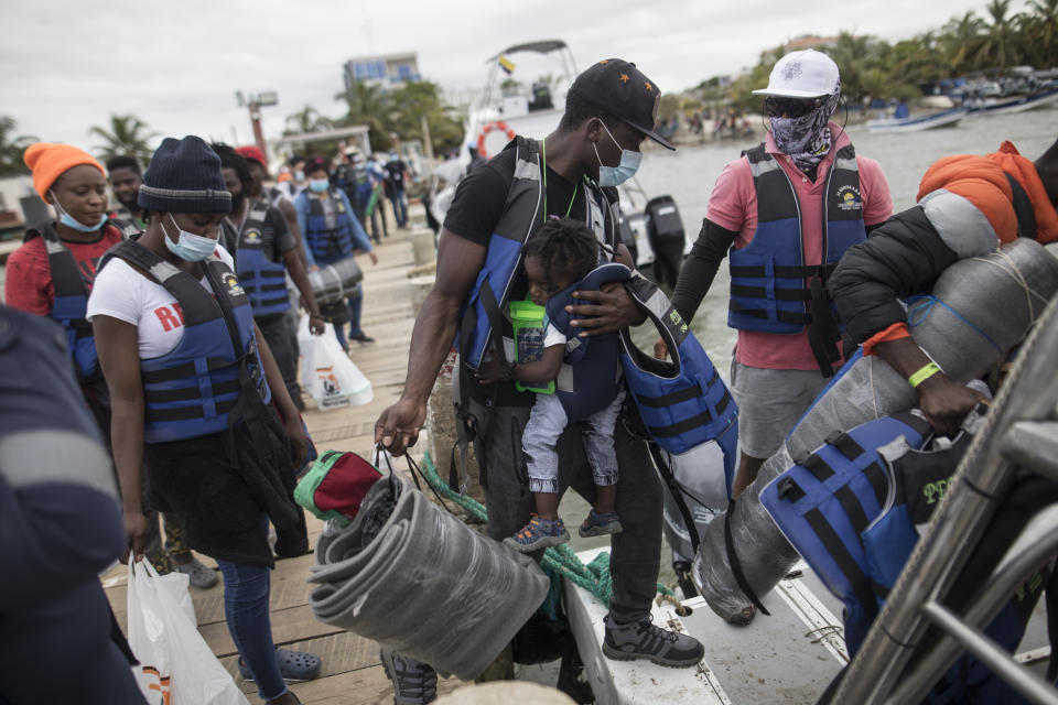 Migrants board a boat that will take them to Capurgana, on the border with Panama, from Necocli, Colombia, Thursday, July 29, 2021. Migrants have been gathering in Necocli as they move north towards Panama on their way to the U.S. border. (AP Photo/Ivan Valencia)