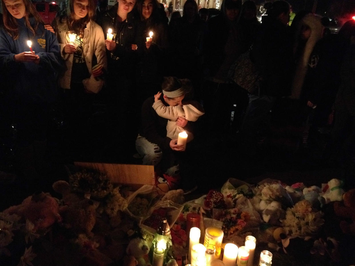 A woman hugs a child at a makeshift memorial in Newtown, Conn.