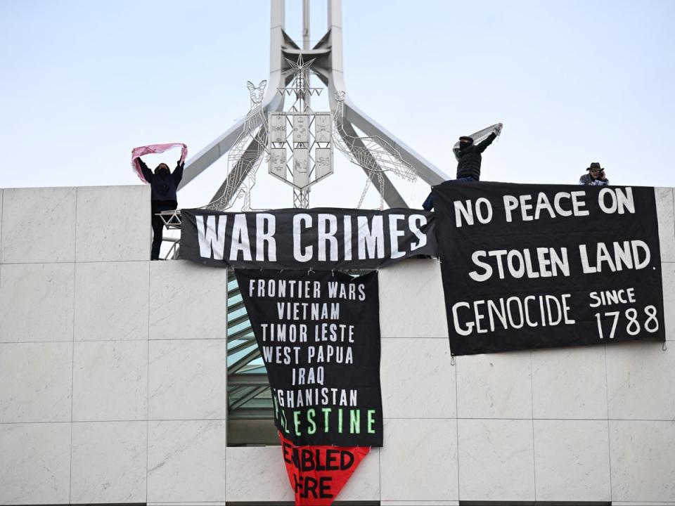 Pro-Palestinian protesters hang banners from the top of the Australian parliament in Canberra on 4 July 2024 (Reuters)