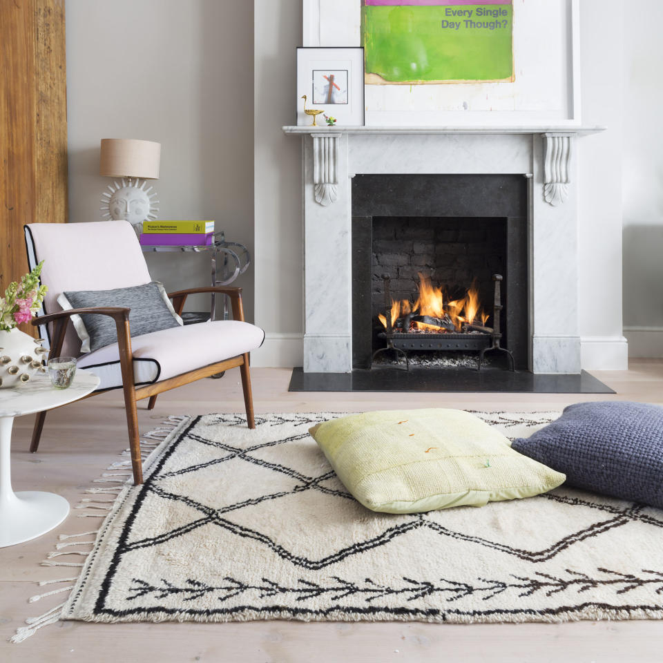 Living room with berber rug, armchair and fireplace.