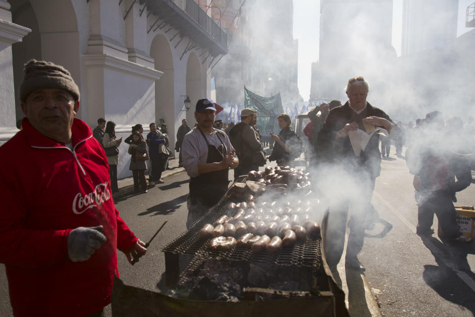 A street vendor sells sausages as demonstrators arrive to Plaza de Mayo in Buenos Aires, Argentina, Wednesday, June 27, 2012. A strike and demonstration called by union leader Hugo Moyano demands steps that would effectively reduce taxes on low-income people, among other measures. (AP Photo/Eduardo Di Baia)