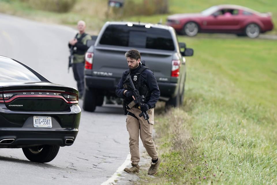 Law enforcement officers hold rifles while investigating a scene, in Bowdoin, Maine, Thursday, Oct. 26, 2023. Residents have been ordered to shelter in place as police continue to search for the suspect of Wednesday's mass shootings. (AP Photo/Steven Senne)