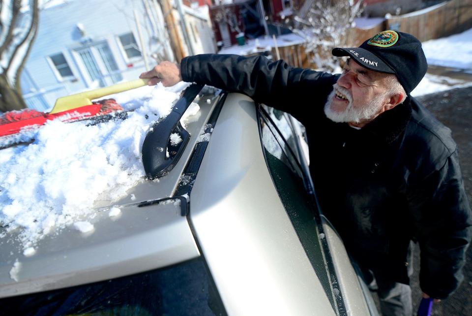 Anibal Maceira, of Hagerstown, Md., cleans snow off the roof of his car Monday morning, Jan. 14, 2019, after a winter storm brought about six inches of snow to the Tri-State area over the weekend.