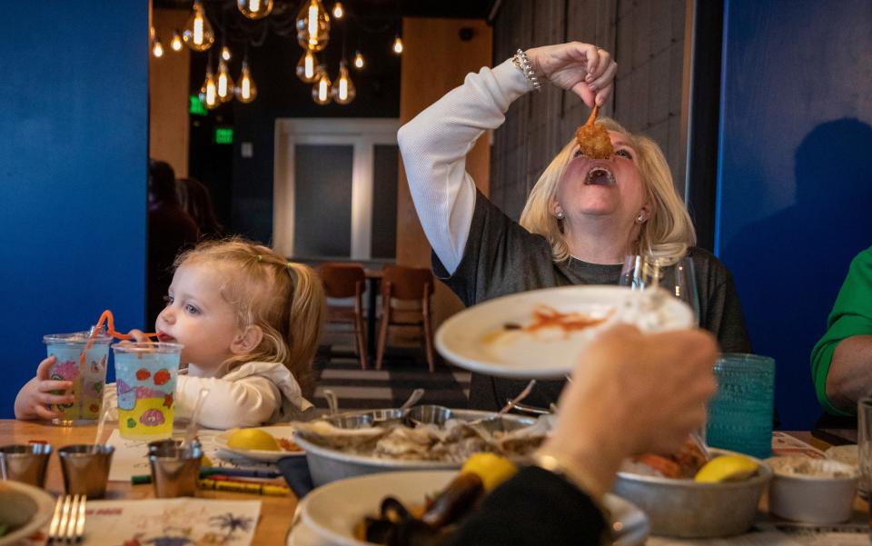 Char Sypitkowski eats a breaded shrimp beside her granddaughter inside HazelÍs Birmingham restaurant on Friday, March 17, 2023. Sypitkowski and her family came to Hazel's to celebrate meatless Friday. 