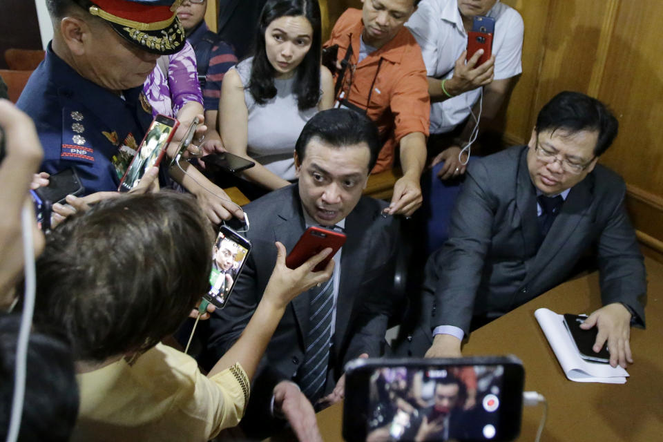 Philippine opposition Senator Antonio Trillanes IV, center, talks to reporters inside the Makati Regional Trial Court Branch 150 after it has issued an order for his arrest Tuesday, Sept. 25, 2018, in suburban Pasay city, south of Manila, Philippines. Trillanes who remained holed up in his office for three weeks now after President Rodrigo Duterte voided an amnesty given to the former rebel military officer, willingly went with police to post bail. (AP Photo/Aaron Favila)