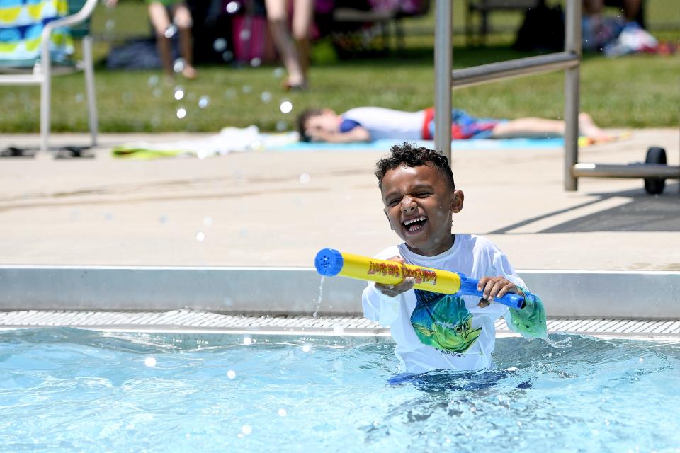 Alexander grant, 5, sprays his cousin with a water gun as he plays in the Owen Pool on May 27, 2019.