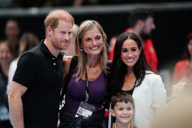 The Duke and Duchess of Sussex posing for photograph as they watch children on the basketball court at the Merkur Spiel-Arena during the Invictus Games in Dusseldorf, Germany. 