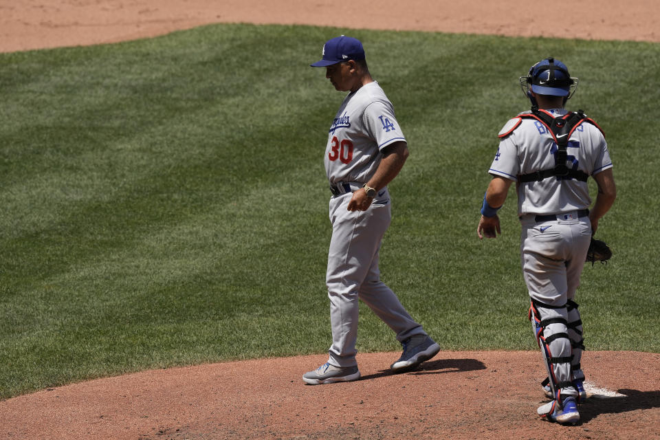 Los Angeles Dodgers' Dave Roberts (30) walks back to the dugout after making a pitching change during the fourth inning of a baseball game against the Kansas City Royals Sunday, July 2, 2023, in Kansas City, Mo. (AP Photo/Charlie Riedel)