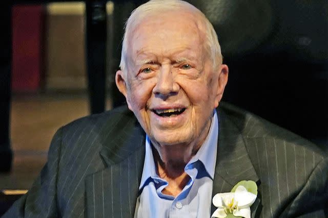 John Bazemore, Pool/AP Former President Jimmy Carter smiles as his wife, former first lady Rosalynn Carter, speaks during a reception to celebrate their 75th wedding anniversary on July 10, 2021, in Plains, Georgia