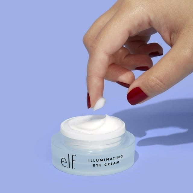 a hand reaching into the eye cream