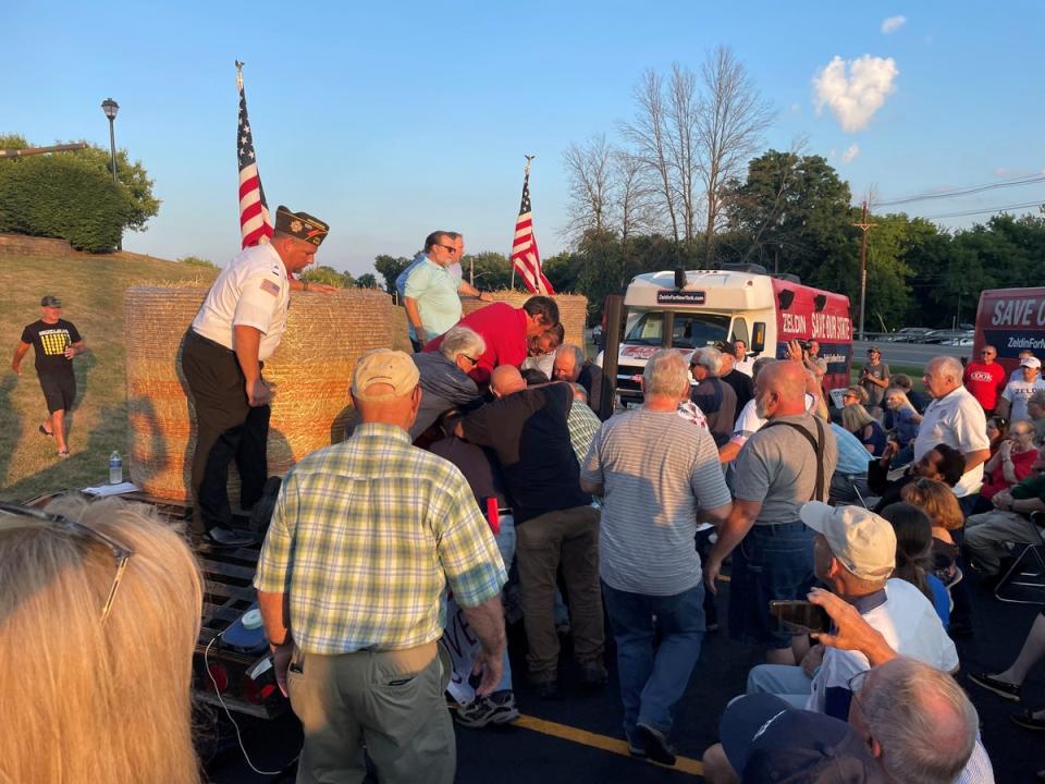 A group of people, attending Congressman Lee Zeldin's stump speech, gather around, what the photographer says was the attacker, after an alleged attack on Zeldin during his stump speech, in Fairport, New York, United States, July 21, 2022 (via REUTERS)