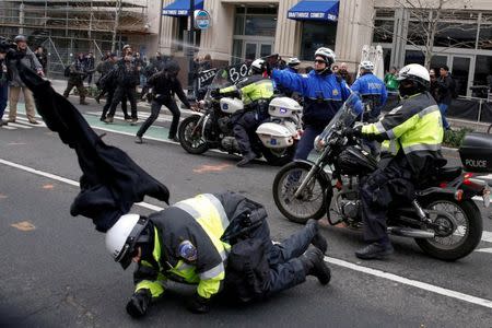 File Photo - A police officer falls to the ground as another shoots pepper spray at protesters demonstrating against U.S. President Donald Trump on the sidelines of the inauguration in Washington, D.C. on January 20, 2017. REUTERS/Adrees Latif/File Photo