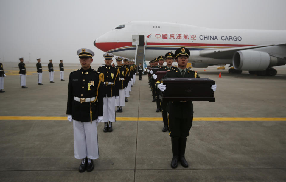 Chinese honor guards, right, hold caskets containing the remains of Chinese soldiers during the handing over ceremony of the remains at the Incheon International Airport in Incheon, South Korea Friday, March 28, 2014. The remains of more than 400 Chinese soldiers killed during the 1950-53 Korean War were transferred from the temporary columbarium in South Korea to the airport to return home for permanent burial. (AP Photo/Kim Hong-ji, Pool)