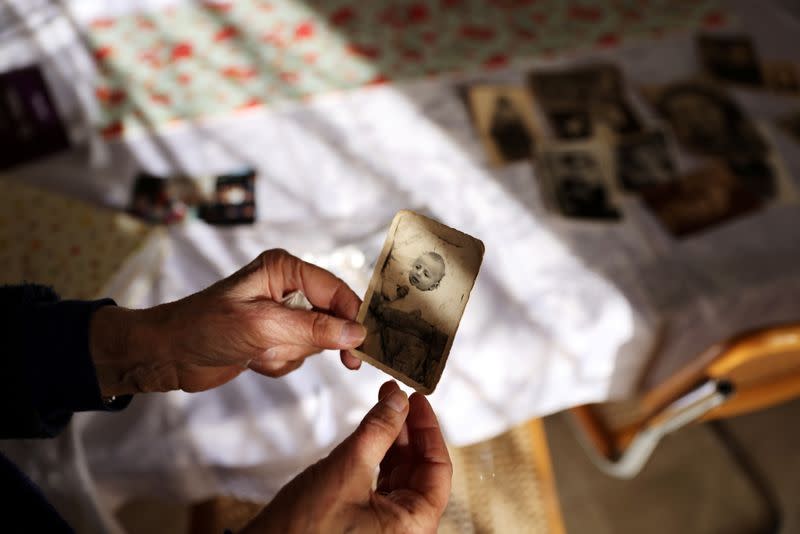 Holocaust survivor Leah Nebenzahl holds a photograph of herself as a baby during her interview with Reuters in Jerusalem