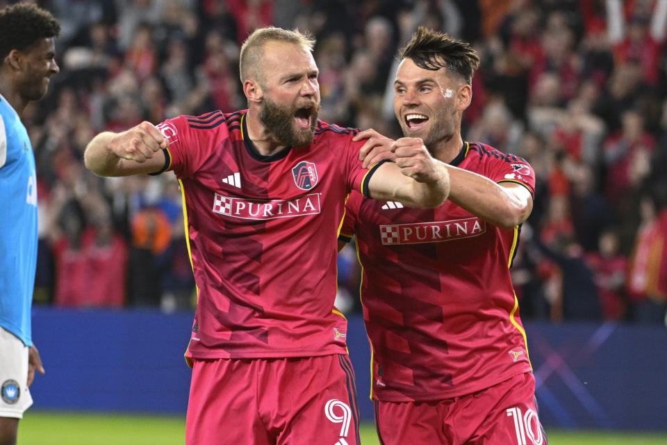 St. Louis City SC forward Klauss (9) and midfielder Eduard Lowen (10) celebrate after Charlotte FC scored an own goal during the first half of an MLS soccer match Saturday, March 4, 2023, in St. Louis. (AP Photo/Joe Puetz)