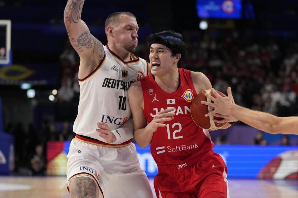 Japan forward Yuta Watanabe (12) tries to drive in against Germany forward Daniel Theis (10) in the second half of the Basketball World Cup group E match between Germany and Japan in Okinawa, southern Japan, Friday, Aug. 25, 2023.