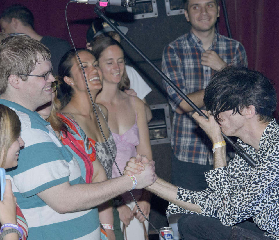 Bradford Cox gets close to fans while playing with the indie rock group Deerhunter, perform at One Eyed Jack's in the French Quarter in New Orleans, Monday, April 29, 2013. (AP Photo/Matthew Hinton)