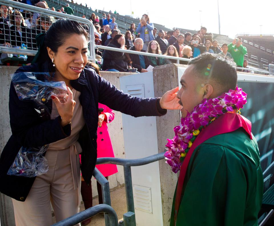 Luisa Inocente, left, congratulates her son Gabriel Inocente during his graduation from the University of Oregon.