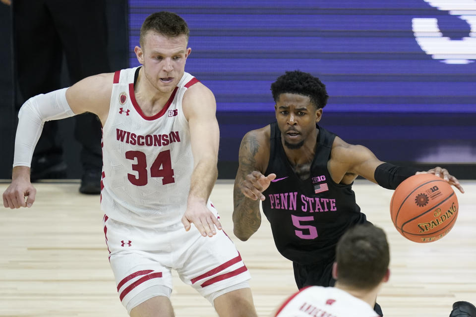 Penn State's Jamari Wheeler (5) goes to the basket against Wisconsin's Brad Davison (34) during the first half of an NCAA college basketball game at the Big Ten Conference tournament, Thursday, March 11, 2021, in Indianapolis. (AP Photo/Darron Cummings)